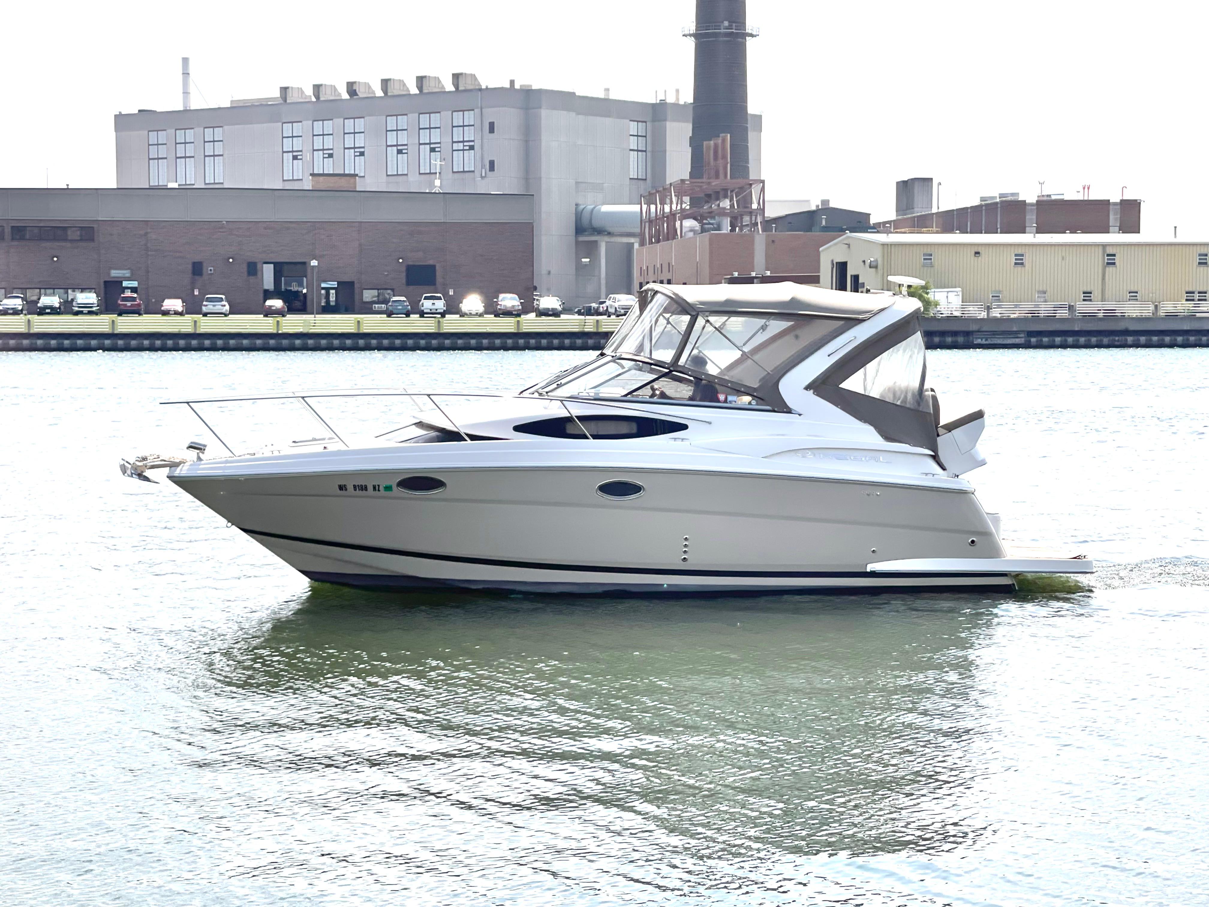 Regal 30 Express 2013 Regal 30 Express boat on water near industrial buildings.