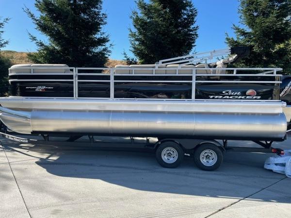 Sun Tracker SportFish 22 XP3 2025 Sun Tracker SportFish 22 XP3 pontoon boat on trailer, parked outdoors.