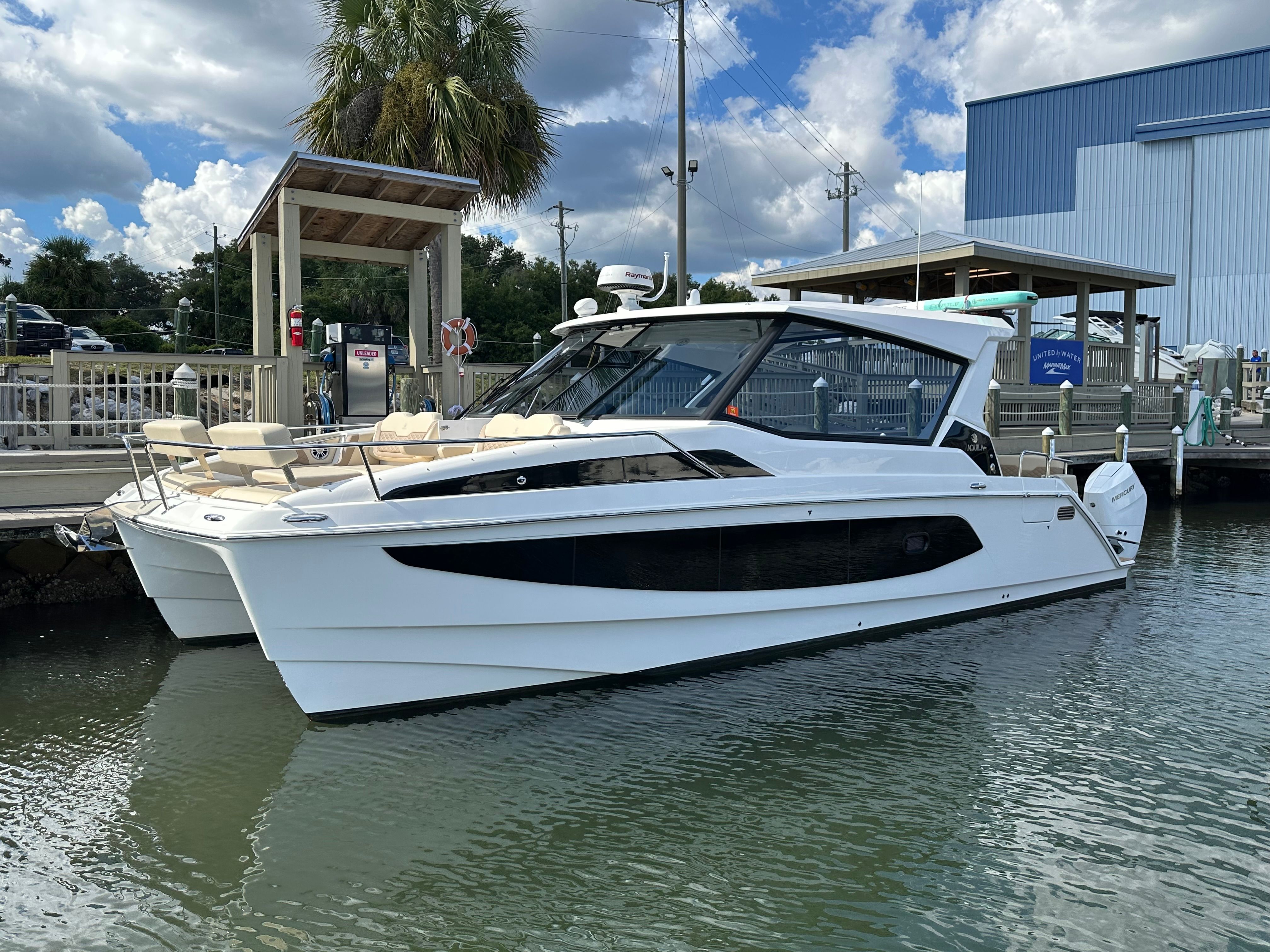 Aquila 36 Sport 2025 Aquila 36 Sport boat docked at marina under blue sky.