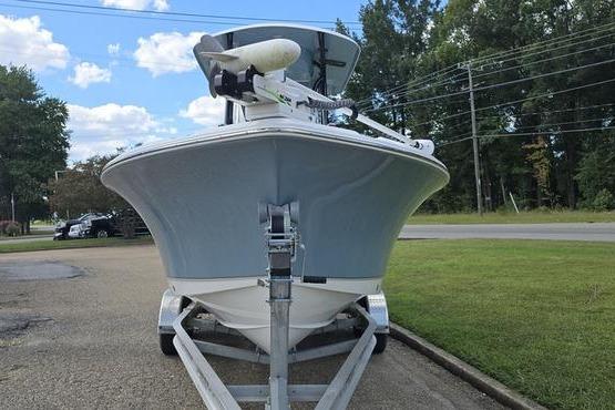 Sea Hunt Ultra 234 2023 Sea Hunt Ultra 234 boat on trailer, parked outdoors, under a partly cloudy sky.