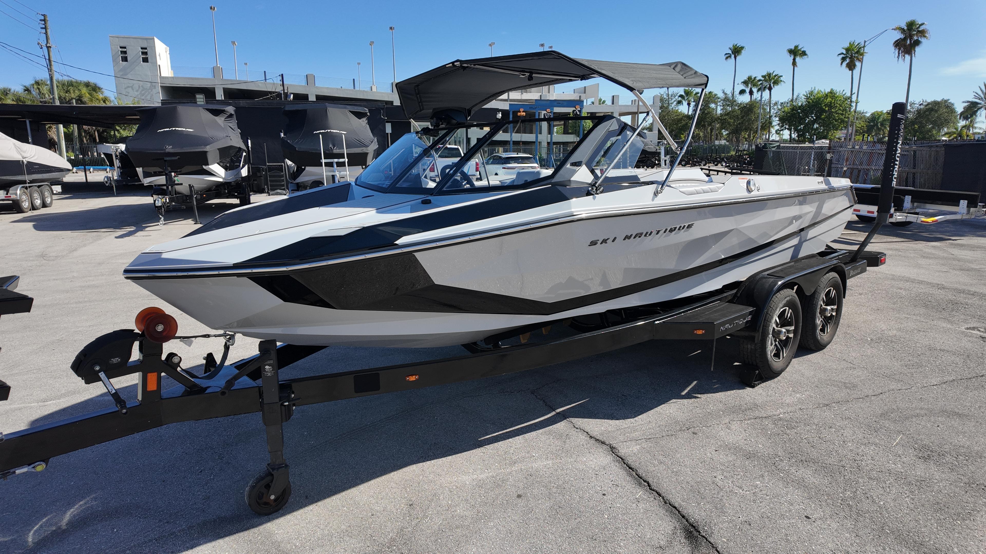 Nautique Ski Nautique 2026 Nautique Ski boat on trailer in sunny marina setting.