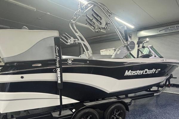 MasterCraft XT23 2018 MasterCraft XT23 boat in a garage, featuring sleek black and white design.