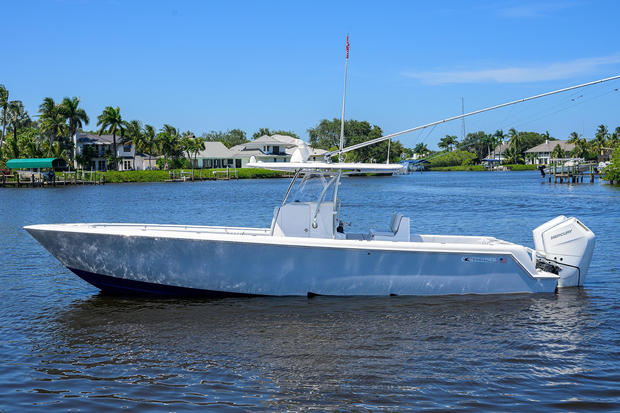 Contender 35 ST 2025 Contender 35 ST boat on a calm river with houses and palm trees.
