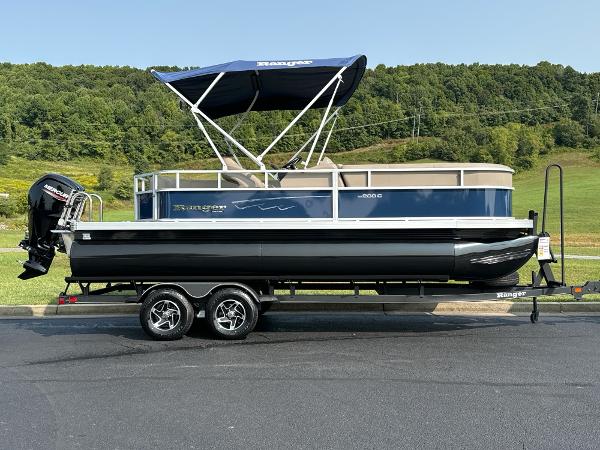 Ranger Reata 200C 2024 Ranger Reata 200C pontoon boat on trailer, blue canopy, scenic background.