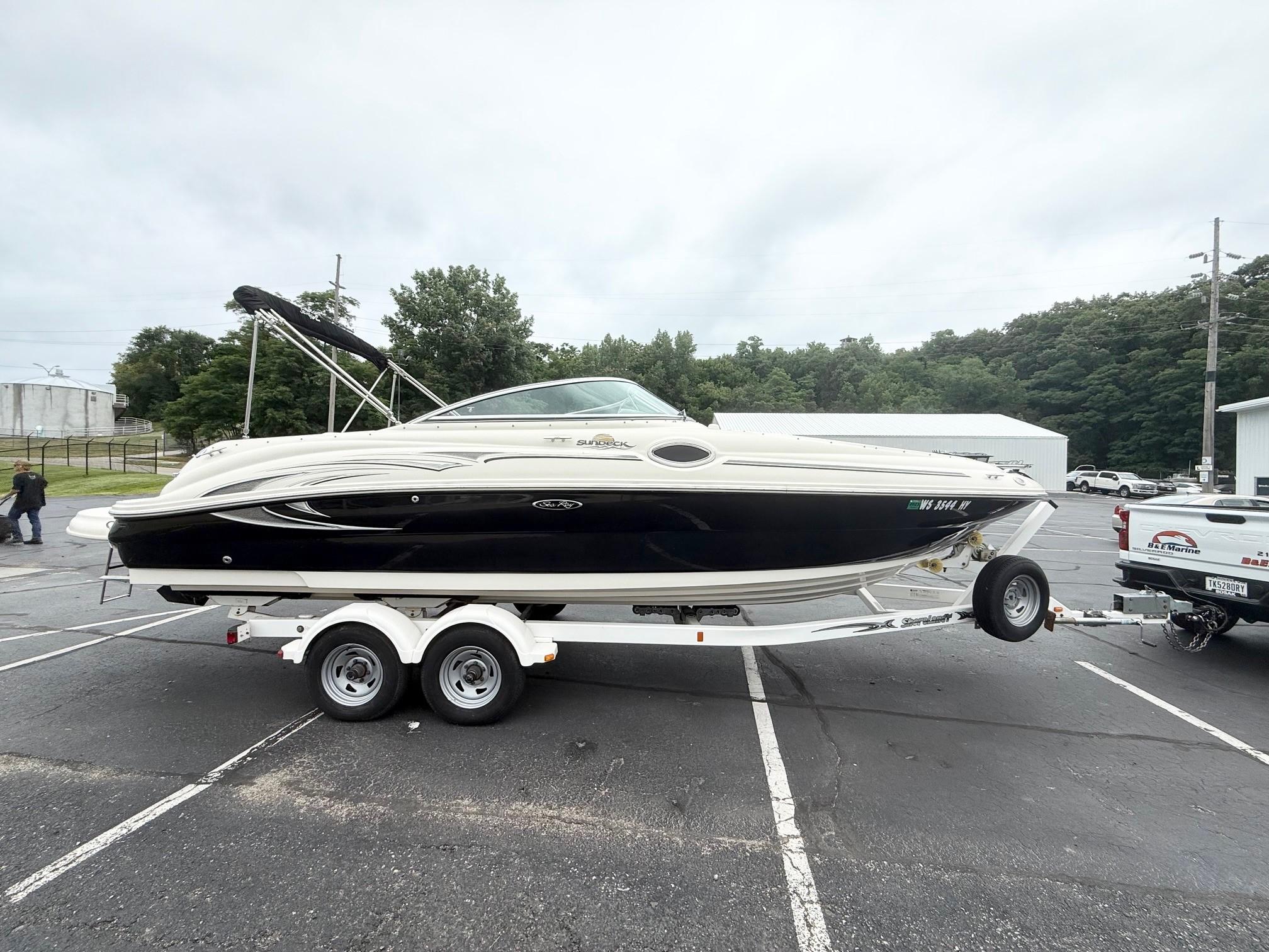 Sea Ray 240 Sundeck 2006 Sea Ray 240 Sundeck boat on trailer in parking lot, overcast sky.