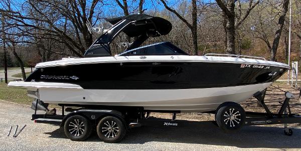 Chaparral 25 SURF 2020 Chaparral 25 SURF boat on trailer, black and white design, parked outdoors.