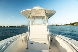 Contender 32 ST 2015 Contender 32 ST boat on calm water, clear sky, and distant shoreline.