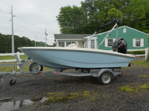 Boston Whaler 130 Super Sport 2025 Boston Whaler 130 Super Sport boat on trailer, parked outdoors near a green house.