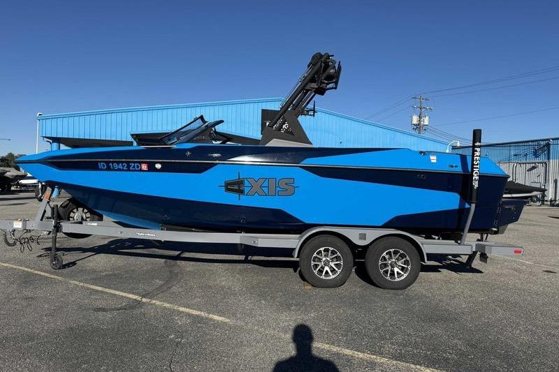 Axis A22 2021 Axis A22 boat in blue on a trailer, parked outdoors.