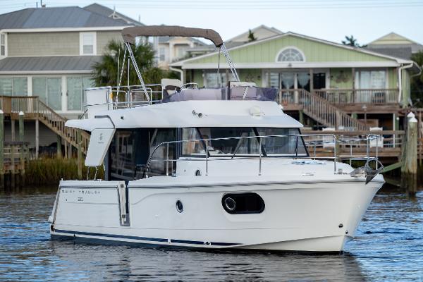 Beneteau Swift Trawler 30 2019 Beneteau Swift Trawler 30 cruising near waterfront homes.