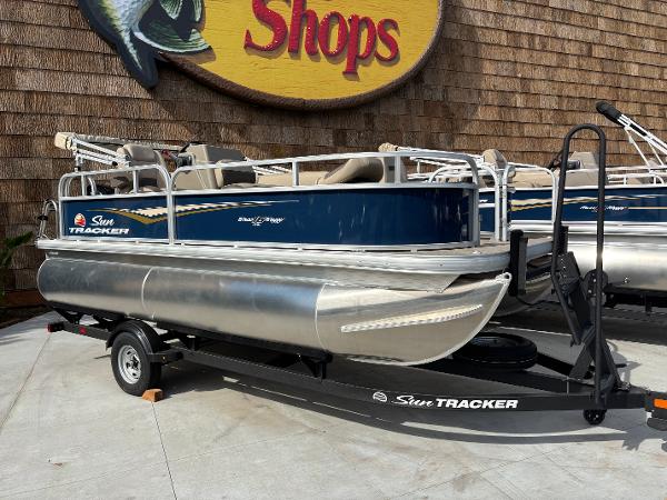 Sun Tracker Bass Buggy 16 XL Select 2025 Sun Tracker Bass Buggy 16 XL Select pontoon boat on trailer, displayed outdoors.