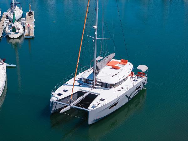 Excess 14 2024 Excess 14 catamaran docked in a marina, featuring sleek design and spacious deck.