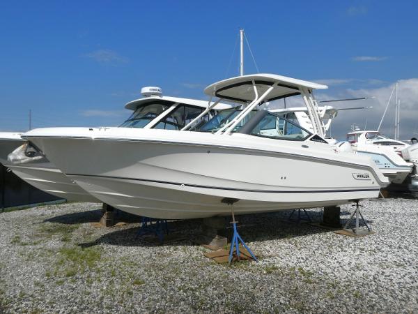 Boston Whaler 240 Vantage 2025 Boston Whaler 240 Vantage boat displayed on gravel lot under clear blue sky.