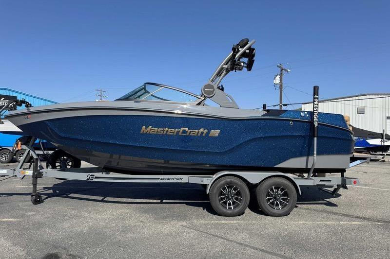 MasterCraft XT22 2026 MasterCraft XT22 boat on trailer, blue exterior, parked outdoors.