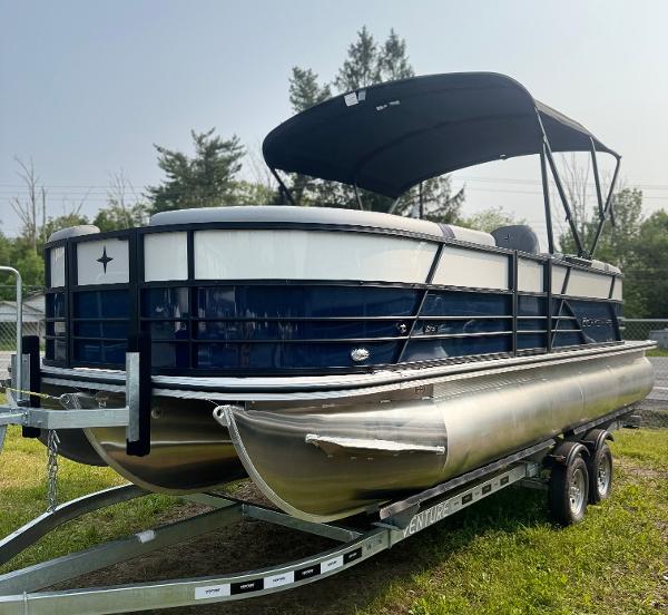 Berkshire 22RFX CTS 2025 Berkshire 22RFX CTS pontoon boat on trailer with canopy, parked on grass.