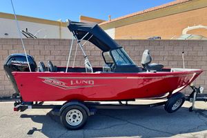 Lund 1650 Rebel XL Sport 2024 Lund 1650 Rebel XL Sport boat, red exterior, on trailer, with Mercury outboard motor.