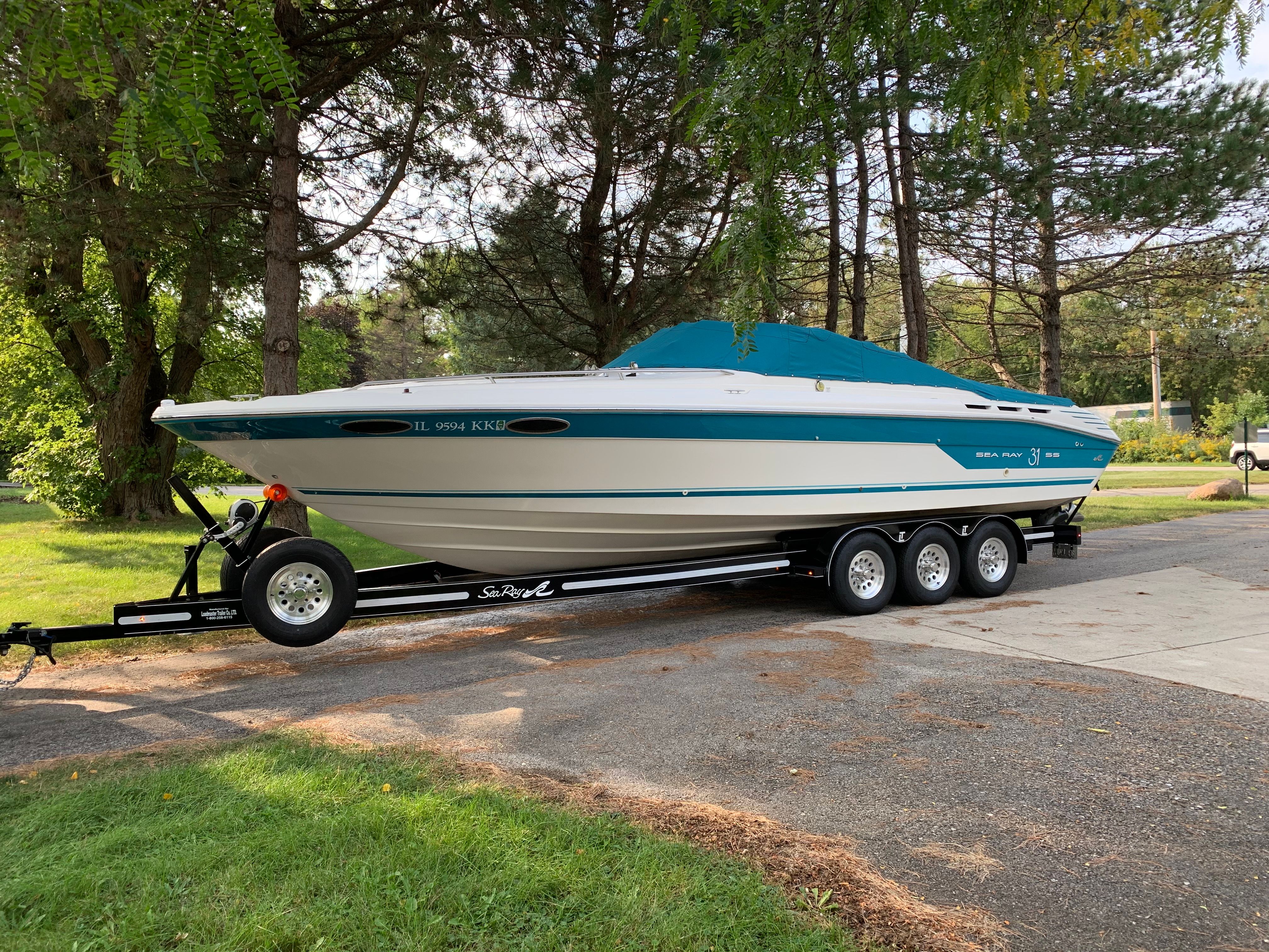 Sea Ray 310 Sunsport 1994 Sea Ray 310 Sunsport boat on trailer, parked outdoors near trees.