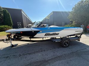 Malibu Response TXi 2023 Malibu Response TXi boat on trailer, parked outdoors under clear sky.