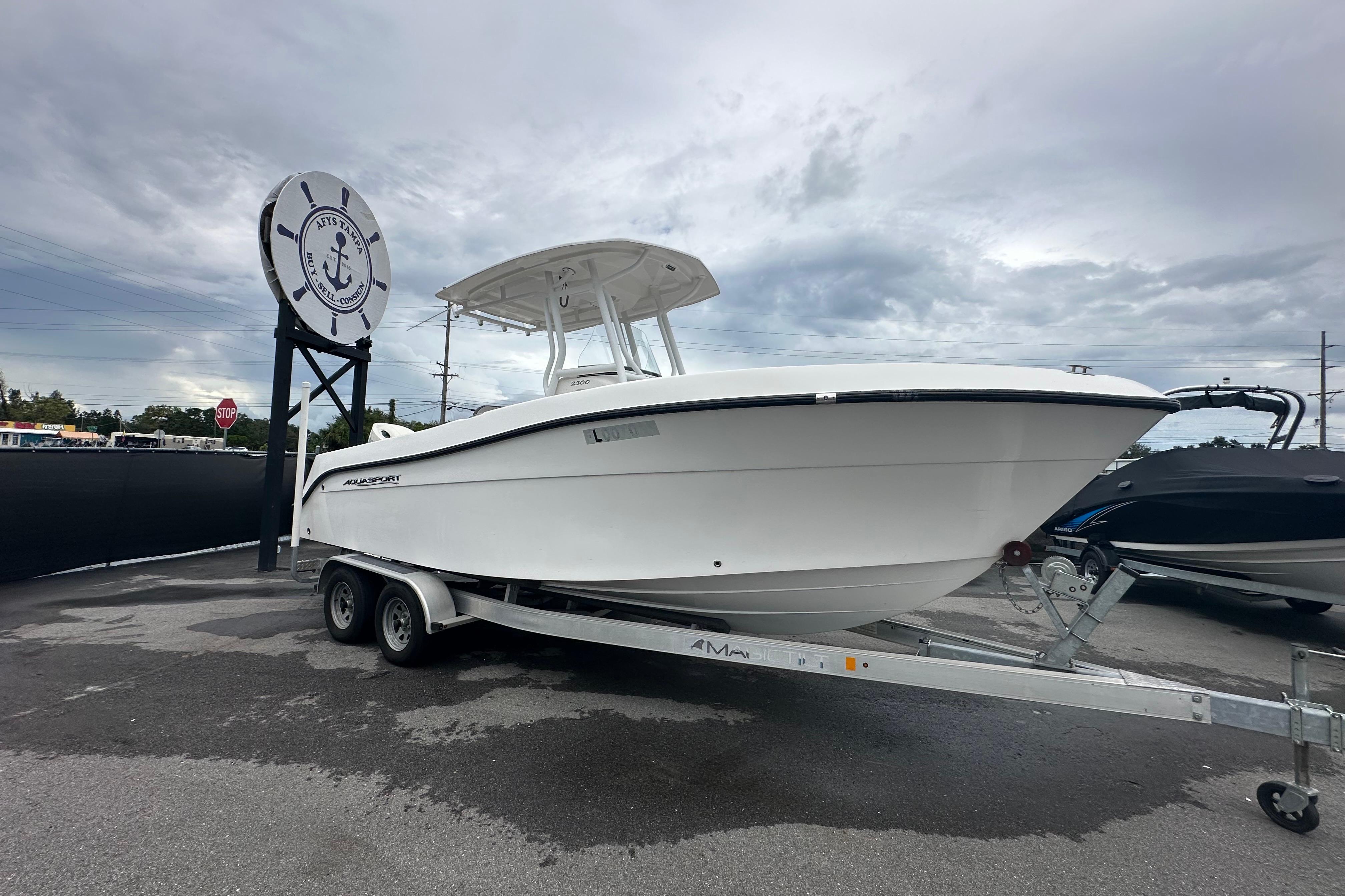 Aquasport 2300 Center Console 2020 Aquasport 2300 Center Console boat on trailer, parked outdoors under cloudy sky.