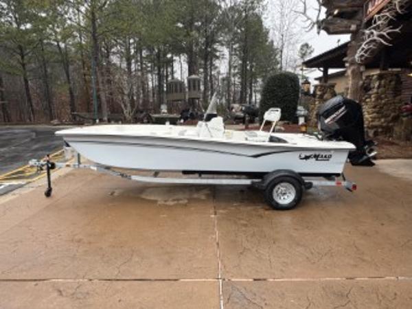 Mako Pro Skiff 17 CC 2025 Mako Pro Skiff 17 CC boat on trailer, parked outdoors.