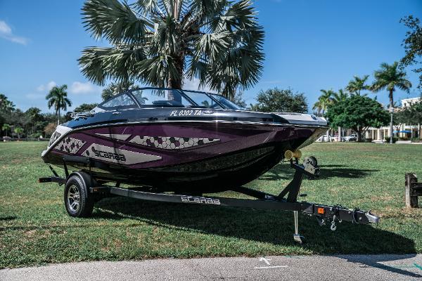 Scarab 195 2021 Scarab 195 boat on trailer in a park with palm trees.