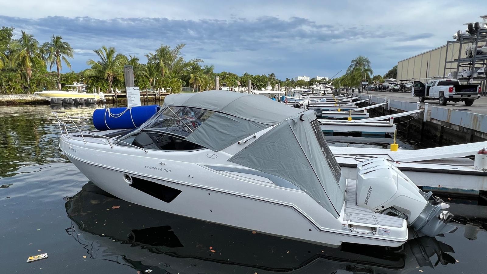 Schaefer 303 Schaefer 303 boat docked at marina, 2021 model, with covered cabin and outboard motor.