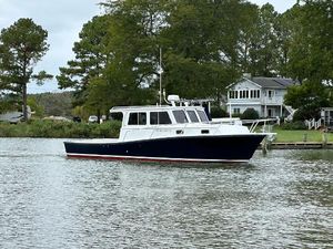 Custom Broad Creek 32 Downeast 2016 Custom Broad Creek 32 Downeast boat on calm water near a house and trees.