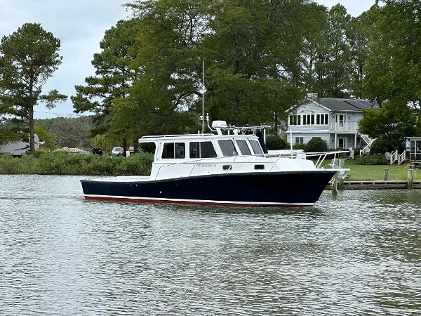 Custom Broad Creek 32 Downeast 2016 Custom Broad Creek 32 Downeast boat on calm water near a house and trees.