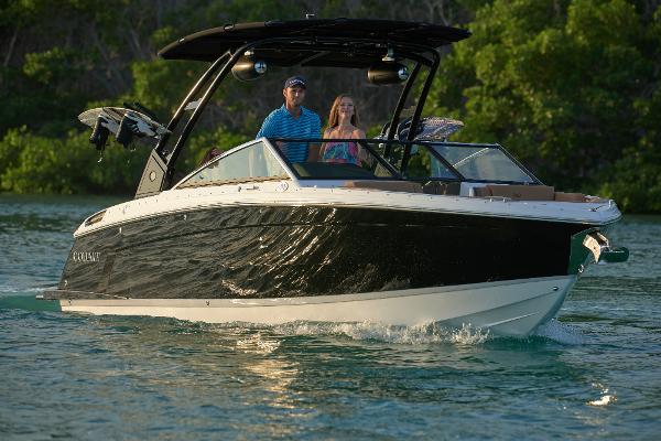Cobalt R6 2025 Cobalt R6 boat cruising on a serene lake with lush greenery.
