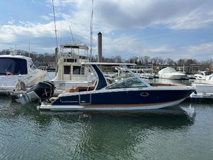 Chaparral 300 OSX 2023 Chaparral 300 OSX boat docked in a marina, surrounded by other vessels.