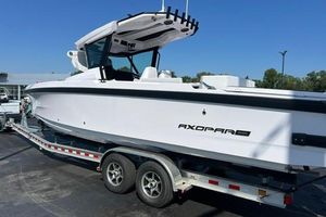 Axopar 29 CCX 2025 Axopar 29 CCX boat on trailer, sleek white design, parked outdoors.