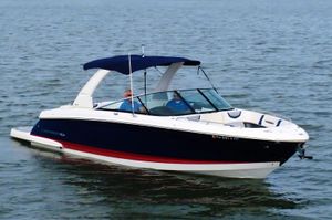 Chaparral 307 SSX 2021 Chaparral 307 SSX boat cruising on open water with blue canopy.