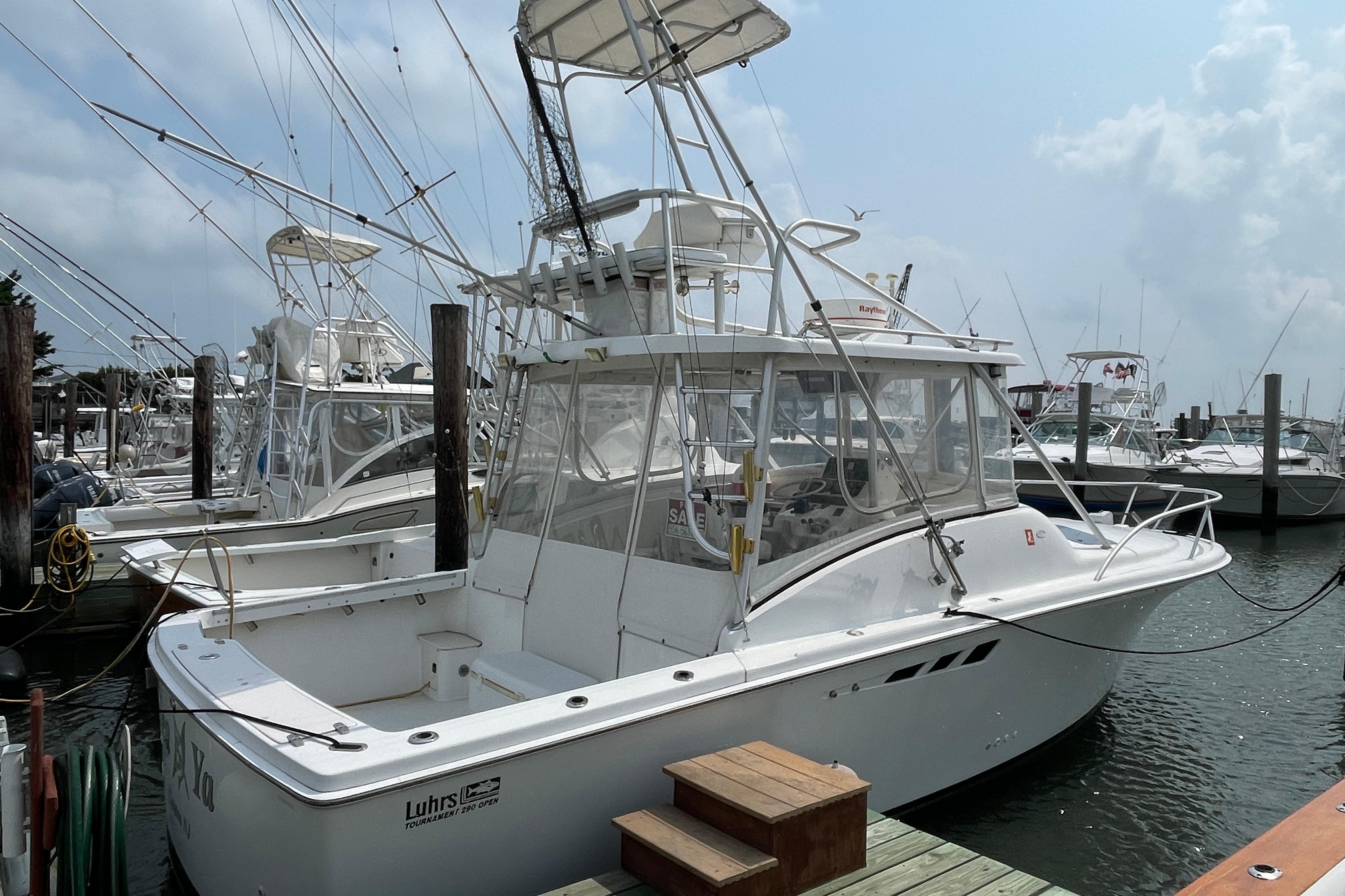 Luhrs Tournament 290 Open 1993 Luhrs Tournament 290 Open boat docked at marina, featuring fishing equipment.