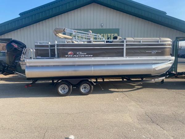 Sun Tracker SportFish 20 DLX 2025 Sun Tracker SportFish 20 DLX pontoon boat on trailer, parked outdoors.