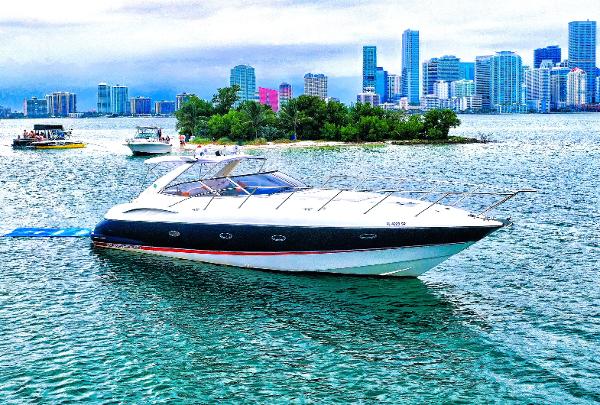 Sunseeker Camargue 44 Sunseeker 44 Camargue 2001 yacht cruising near city skyline and small island.