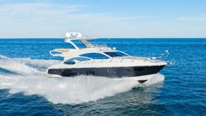 Azimut 60 Flybridge Azimut 60 Flybridge 2017 yacht cruising on open sea under clear blue sky.