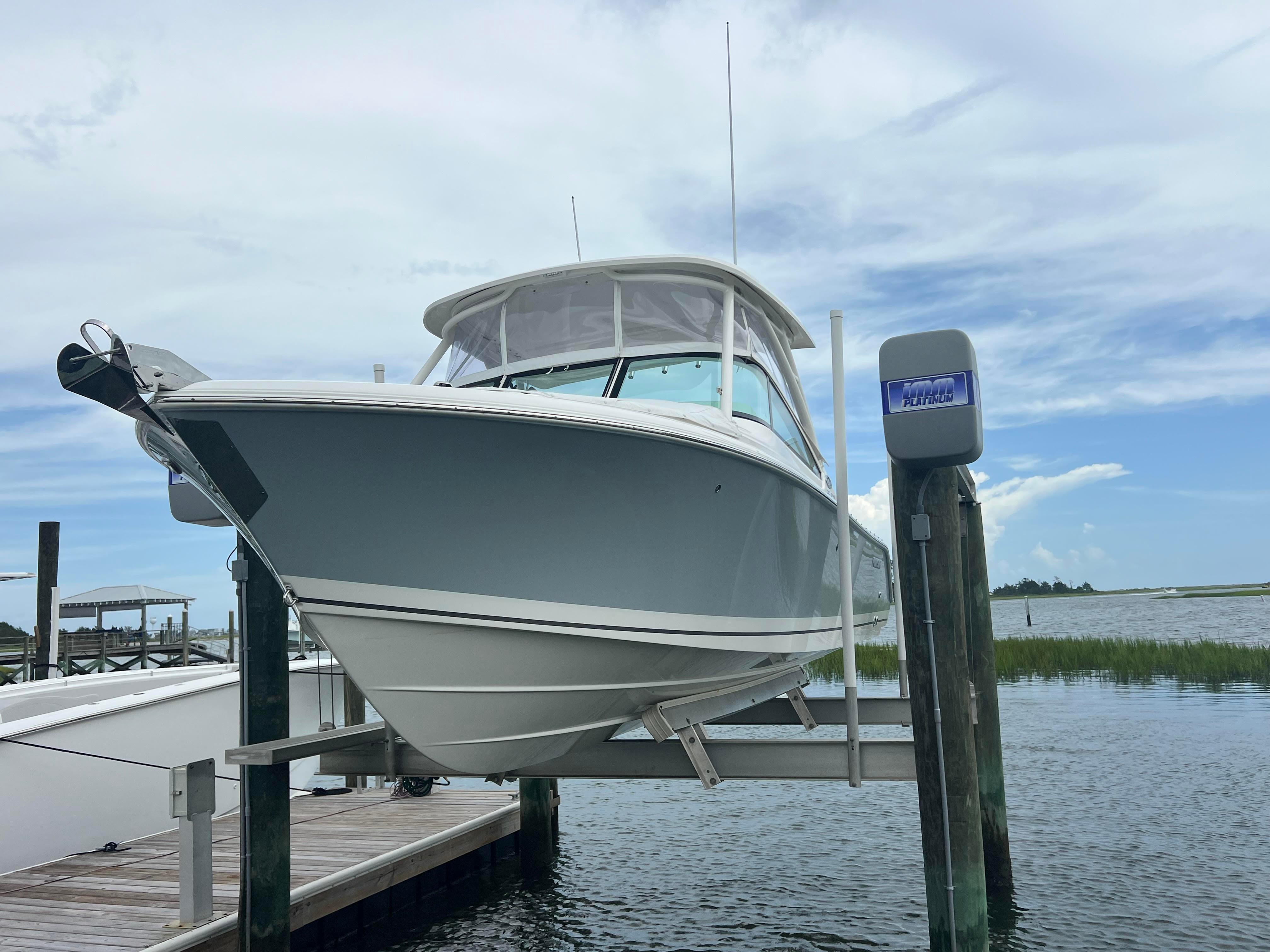 Pursuit DC 246 Dual Console 2025 Pursuit DC 246 Dual Console boat on lift at marina dock.