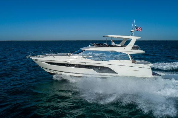 Prestige 590 Luxury 2020 Prestige 590 yacht cruising on open sea under clear blue sky.