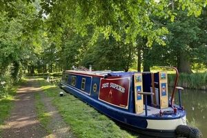 Narrowboat 41ft 41ft Semi Trad narrowboat moored on a scenic canal, surrounded by lush greenery.