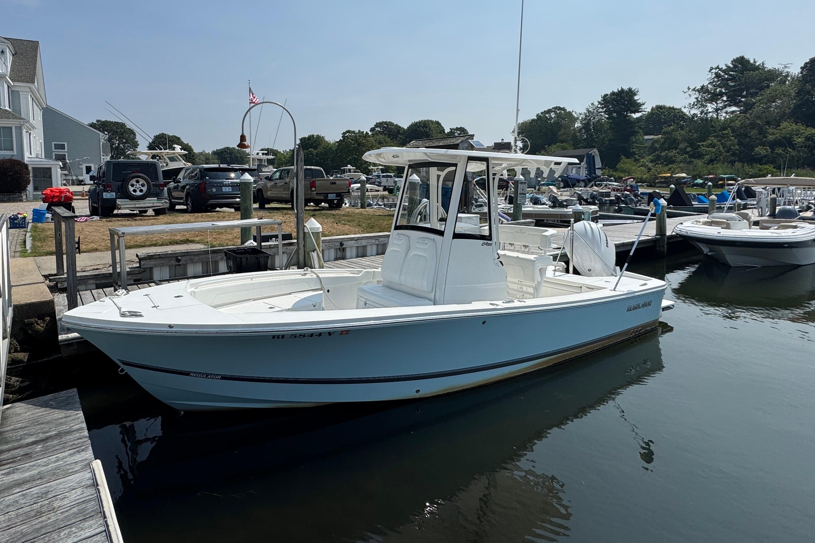 Regulator 24XO 2021 Regulator 24XO boat docked at marina, surrounded by vehicles and other boats.