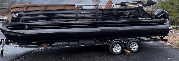 Regency 250 LE3 2023 Regency 250 LE3 pontoon boat on trailer, sleek black design.