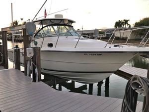 Pursuit 3070 Offshore 2004 Pursuit 3070 Offshore boat docked at marina, surrounded by calm water and palm trees.