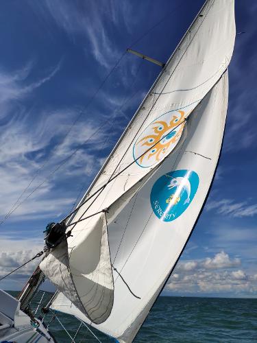 Custom Kelt 9 Sailing yacht Kelt 9, 1986 model, with vibrant sails against a clear blue sky.