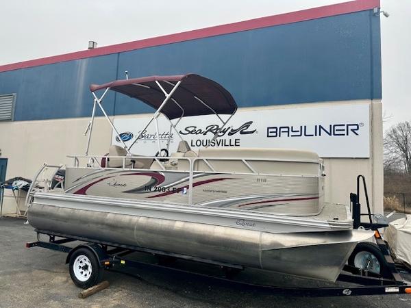 Qwest 818 2019 Qwest 818 pontoon boat on trailer, parked outside dealership with signage.