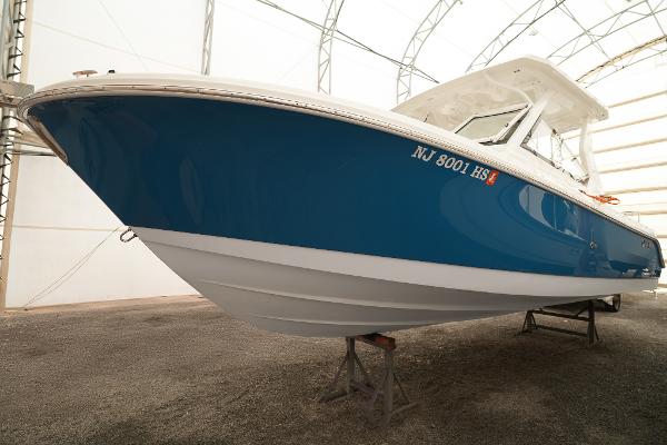 Edgewater 262 CX 2022 Edgewater 262 CX boat in storage, blue hull, side view.