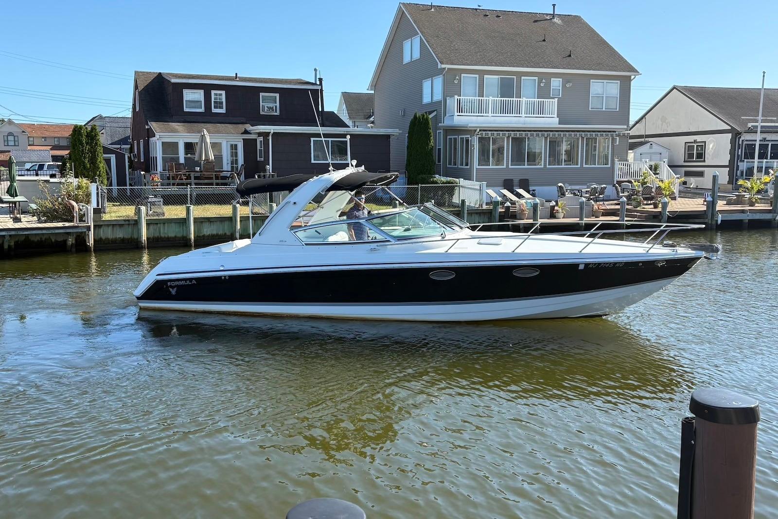 Formula 330 Sun Sport 2004 Formula 330 Sun Sport boat cruising near waterfront homes.