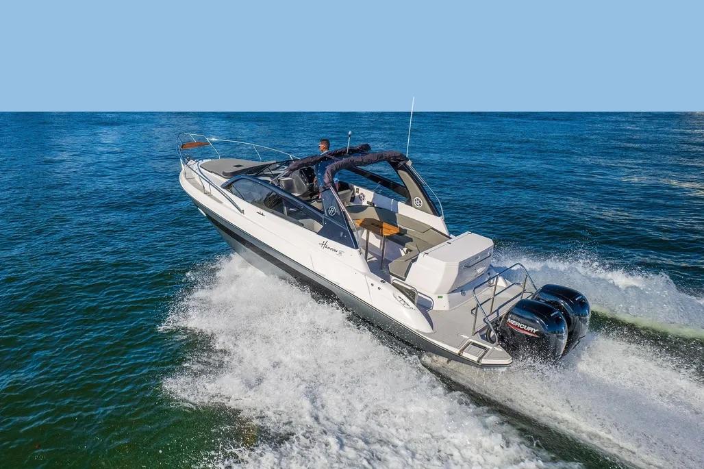 Hanover 305 2025 Hanover 305 boat cruising on open water with dual Mercury engines.