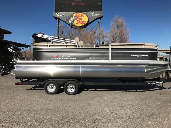 Sun Tracker Party Barge 22 DLX 2025 Sun Tracker Party Barge 22 DLX pontoon boat on trailer, parked outdoors.