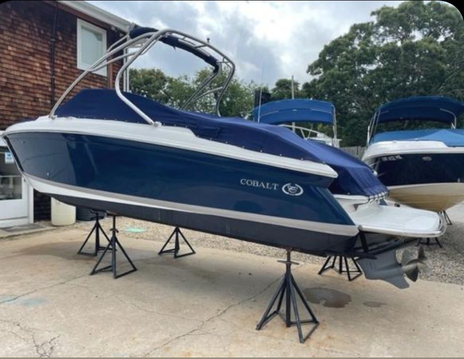 Cobalt 252 2007 Cobalt 252 boat on stands, blue hull, covered, outdoor setting.