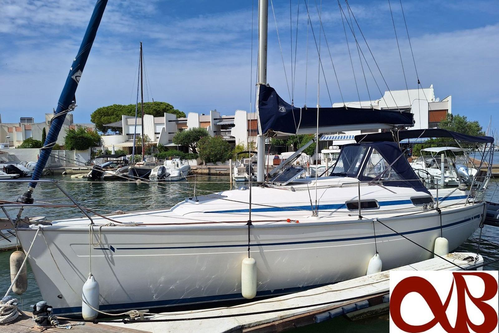 Bavaria 31 Sailboat Bavaria 31, 2000 model, docked in a marina with modern buildings in the background.